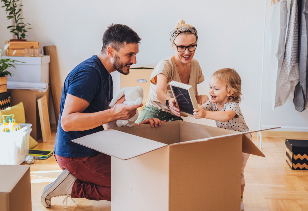 young family unpacking a moving box