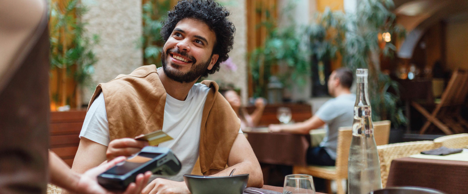 a young man paying with a credit card at a restaurant